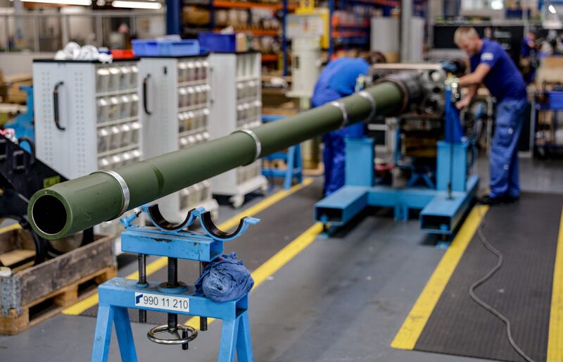 Technicians of German armaments company and automotive supplier Rheinmetall work on a 120mm cannon for Leopard battle tanks that will be delivered to Ukrainian forces. AFP