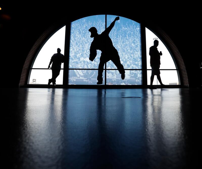 Fans stand near a mural at Minute Maid Park before Game 1 of baseball's American League Championship Series between the Houston Astros and the New York Yankees Friday. AP Photo / Eric Gay.