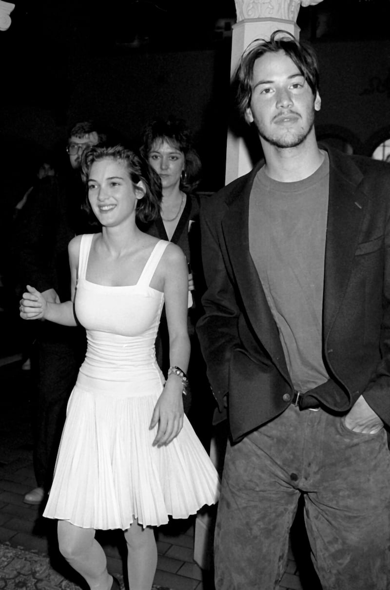 Winona Ryder, accompanied by Keanu Reeves, wears a fitted white top and matching skirt at the Fourth Annual Independent Spirit Awards on March 25, 1989, at the Hollywood Roosevelt Hotel in Hollywood, California. Getty