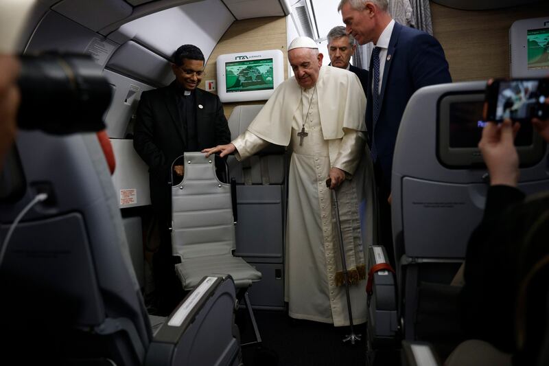 Pope Francis walks with a cane on board his plane after finishing his tour of Canada. EPA