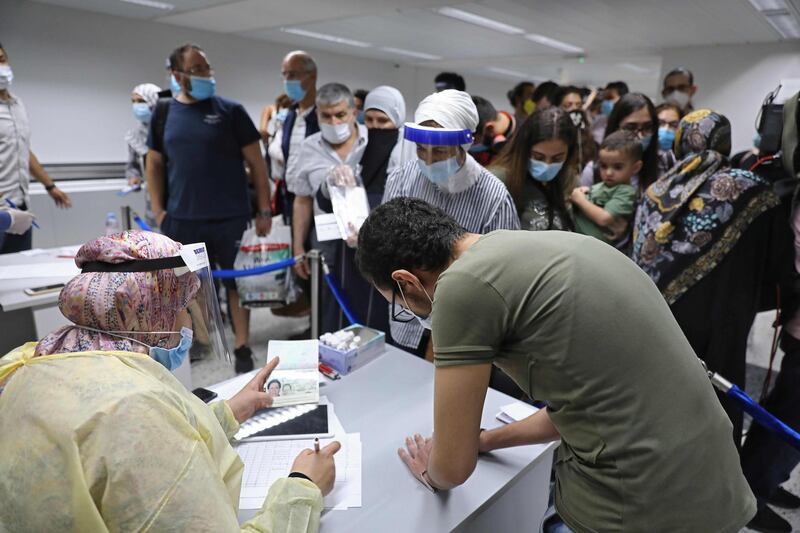 People arriving at Beirut international airport stop at a counter manned by health workers as the airport re-opens in the Lebanese capital. AFP