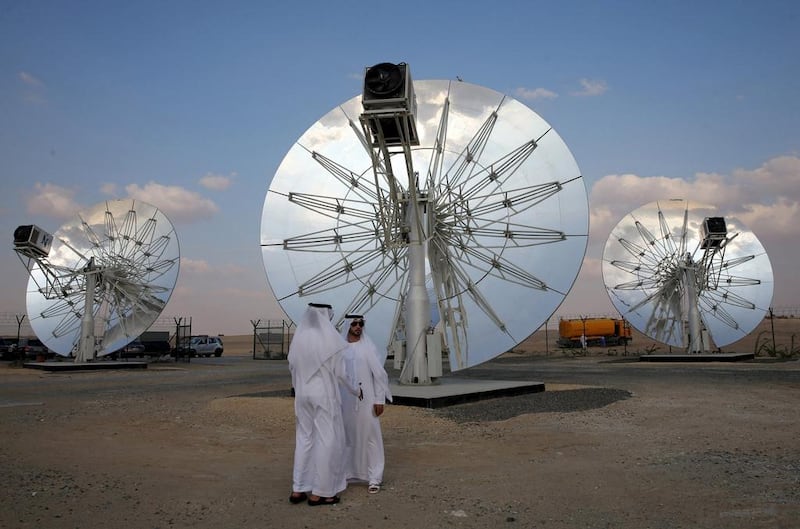 Men stand in front of solar panels at the Mohammed bin Rashid Al Maktoum Solar Park in Dubai. Reuters