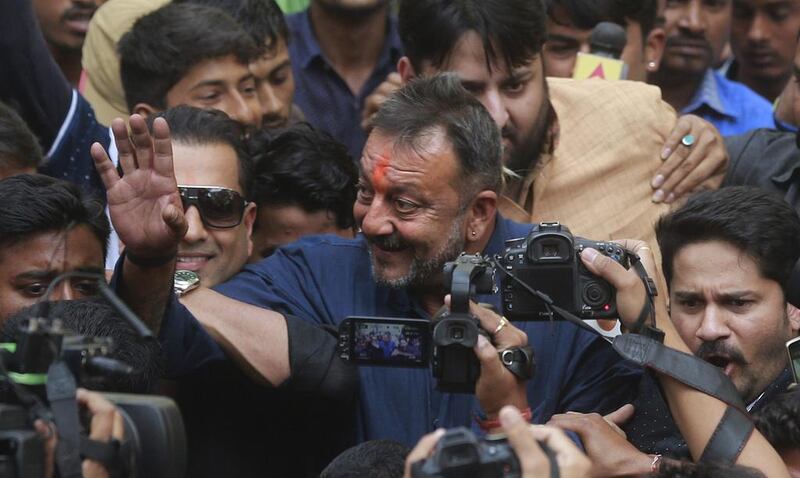 Bollywood actor Sanjay Dutt centre, waves  to his fans as he arrives at his residence in Mumbai, India, Thursday, February 25, 2016. AP Photo
