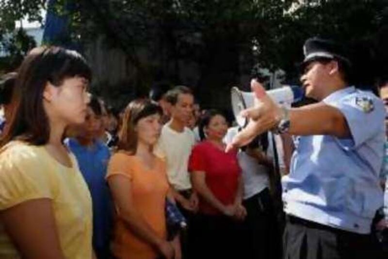 A policeman urges workers from Smart Union gathering outside a closed factory to leave, in the township of Zhangmutou, north of China's southern city of Shenzhen October 17, 2008. Distressed toy maker Smart Union Group said on Friday it was seeking to wind up operations and provisional liquidators had been appointed for the company. Workers gathered outside the Smart Union factory and the government building, demanding unpaid wages as the global economic crisis worsened the outlook for an industry already threatened by falling exports.   REUTERS/Bobby Yip   (CHINA) *** Local Caption ***  ZHA10_CHINA-TOYS-_1017_11.JPG
