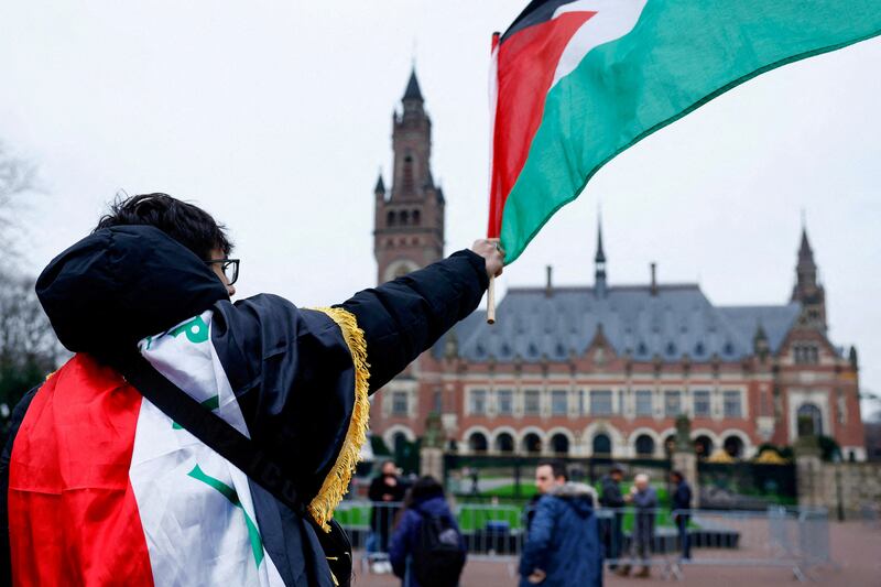 A man waves a Palestinian flag outside the International Court of Justice in The Hague, Netherlands. Reuters