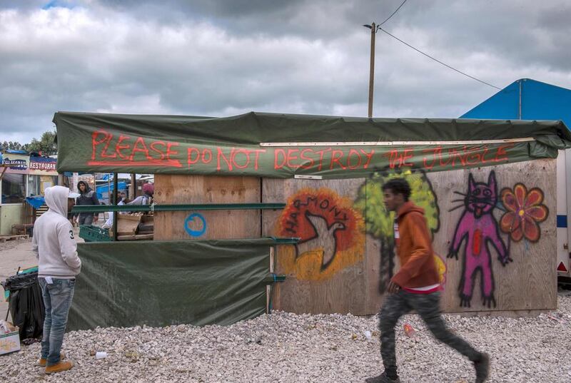 A shop at the Jungle mirant camp in Calais, France, spray-painted with spray-painted with the words "Please do not destroy the Jungle" , October 12, 2016. French authorities are preparing to raze the Calais "Jungle" camp and hav begun moving some unaccompanied children to Britain. Philippe Huguen / AFP