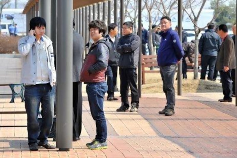 South Korean workers talk outside the inter-Korean transit office after being refused access to Kaesong joint industrial park in North Korea.