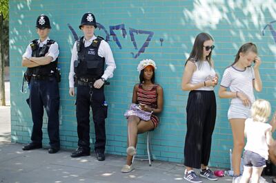 Police officers keep an eye out on the first day of the Notting Hill Carnival in west London on August 27, 2017. 
Nearly one million people are expected by the organizers Sunday and Monday in the streets of west London's Notting Hill to celebrate Caribbean culture at a carnival considered the largest street demonstration in Europe. / AFP PHOTO / Tolga AKMEN