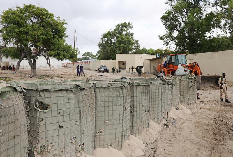 Workers clear the scene after a suicide car bomber drove into a checkpoint outside the port in Mogadishu. Reuters