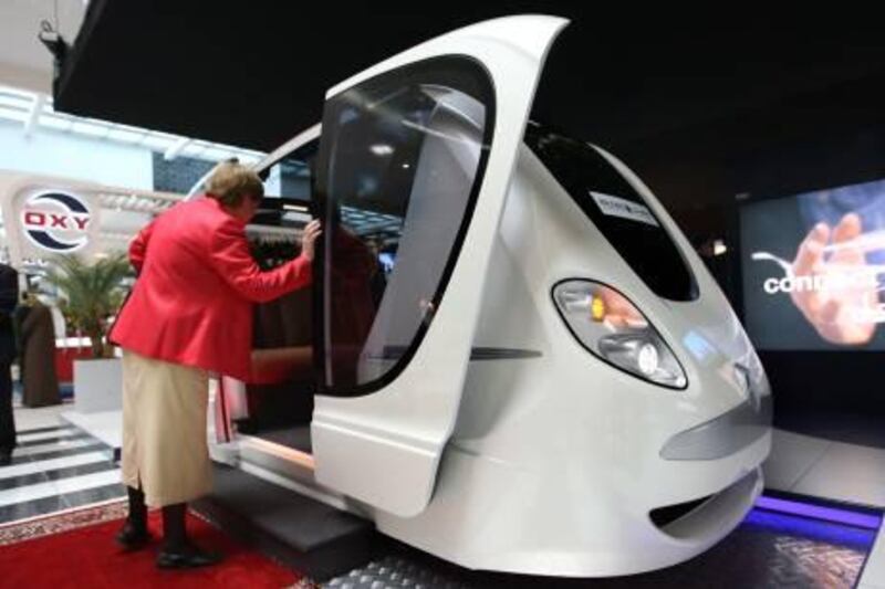 ABU DHABI. 19th Jan.2009. WORLD FUTURE ENERGY SUMMIT. OPENING DAY.A delegate looks inside the solar powered Masdar City car on the first day of the World Future Energy Conference in Abu Dhabi yesterday (mon).  Stephen Lock  /  The National.   *** Local Caption ***  SL-energy-013.jpg