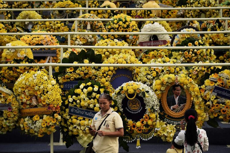 People take photographs with mourning wreaths during a ceremony to commemorate the 3rd anniversary of the death of the late Thai King Bhumibol  in front of the Grand Palace in Bangkok.  AFP