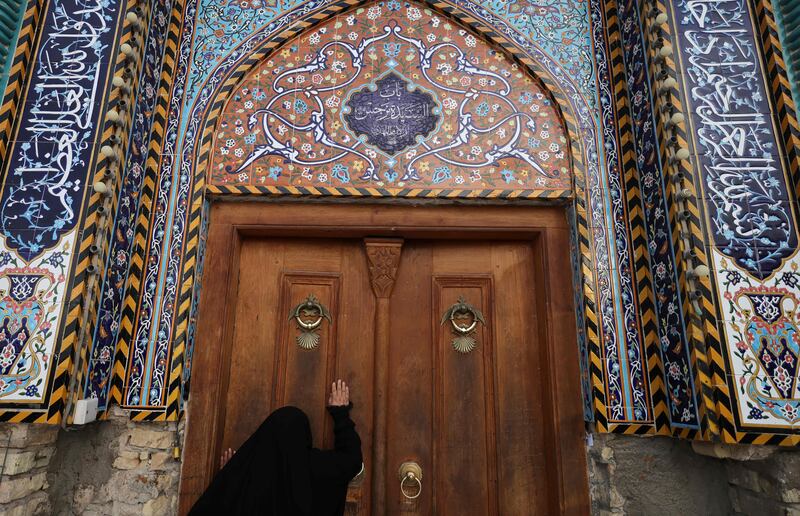 A Shiite pilgrim touches the door of the shrine of 8th-century Imam Musa al-Kadhim to commemorate his death in the Kadhimiya district north of Baghdad. Pilgrims from various Iraqi provinces undertake a march on foot to reach the shrine in the capital to commemorate the 795 CE death of Imam Musa, who is believed to have been poisoned by agents of the then ruler Harun al-Rashid.  AFP