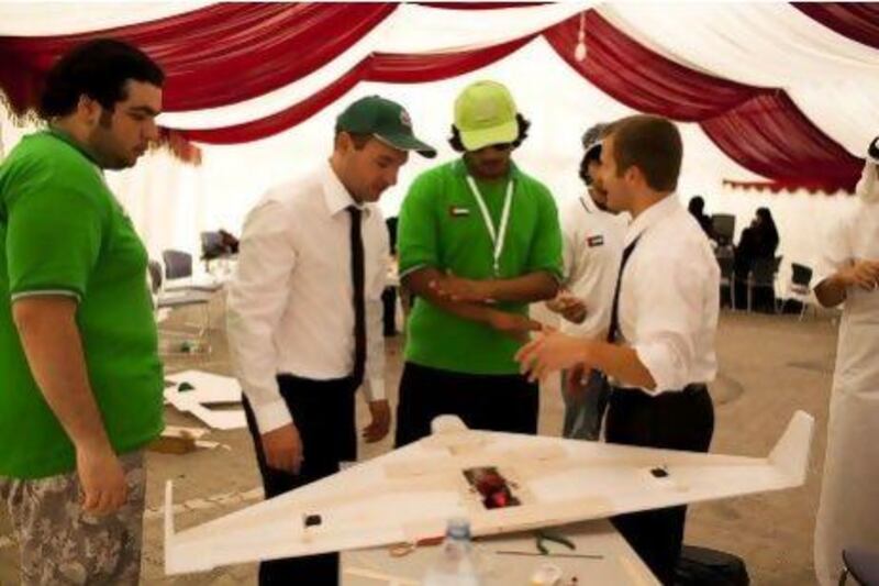 A Northrop Grumman employee demonstrates how to launch a model aeroplane before a student competition in Abu Dhabi.