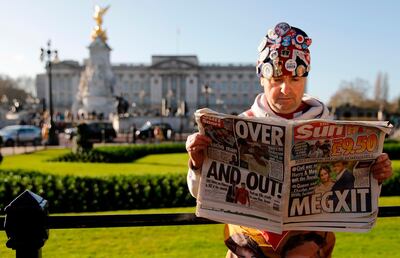 Royal super fan John Loughery holds a copy of a British newspaper as he poses for the media outside of Buckingham Palace in London on January 9, 2020, following the announcement that Britain's Prince Harry, Duke of Sussex and his wife Meghan, Duchess of Sussex, plan to step down as "senior" members of the Royal Family. Britain's Prince Harry and his wife Meghan stunned the British monarchy on Wednesday by quitting as front-line members -- reportedly without first consulting Queen Elizabeth II. In a shock announcement, the couple said they would spend time in North America and rip up long-established relations with the press. Media reports said the Duke and Duchess of Sussex made their bombshell statement without notifying either Harry's grandmother the monarch, or his father Prince Charles. / AFP / Tolga AKMEN
