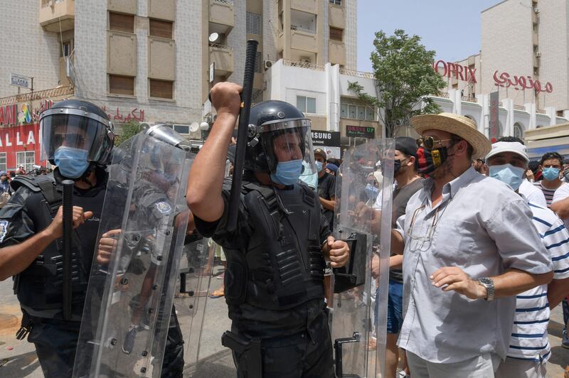 Members of the Tunisian security forces face off with anti-government demonstrators during a rally in front of the Parliament in the capital Tunis.