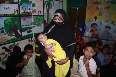 A mother comforts her child at a shelter during the cyclone's landfall, at Shahpori Dwip, near Cox's Bazar. EPA