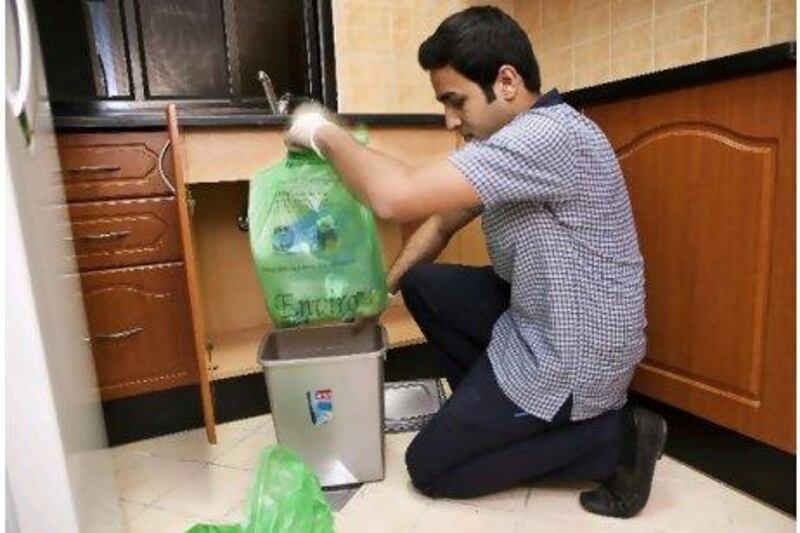 Hassan Naseer, a housekeeper at the Ramada Hotel in Ajman, separates waste to be used for compost in one of the room's kitchens as part of a major new trend in the hospitality sector.