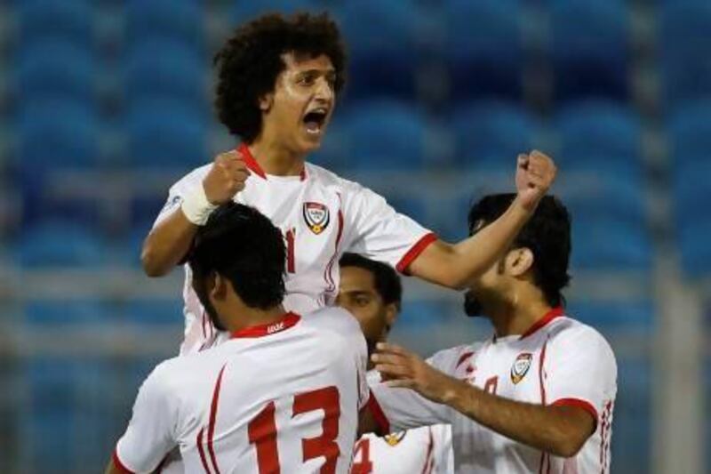 UAE's Omar Abdulrahman celebrates with his teammates after scoring against Qatar.
