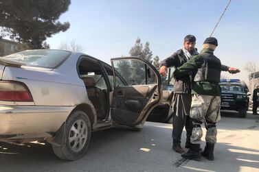 Afghan security officials check vehicles at a checkpoint in Kabul. EPA  