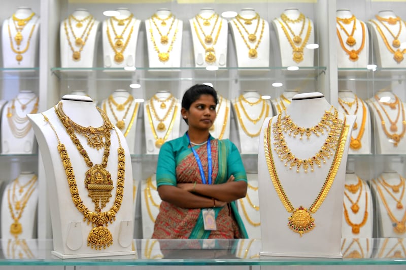 A saleswoman stands next to gold necklaces at a jewellery store in Bangalore on July 5, 2019.
 India's newly re-elected government promised on July 5 an easing of foreign investment rules and more infrastructure spending in an effort to boost flagging growth rates and create jobs. India has been leap-frogged by China as the world's fastest-growing major economy, with unemployment in Asia's third-biggest economy at its highest since the 1970s.
 / AFP / MANJUNATH KIRAN
