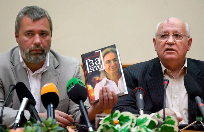 Dmitry Muratov with former Soviet president Mikhail Gorbachev in 2007, holding a book about murdered journalist Anna Politkovskaya. EPA