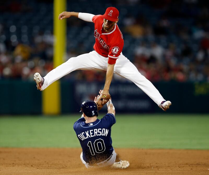 Tampa Bay Rays designated hitter Corey Dickerson slides under Los Angeles Angels shortstop Andrelton Simmons to steal second base, on an errant throw from the catcher during the game's seventh innings in Anaheim, California. Alex Gallardo.