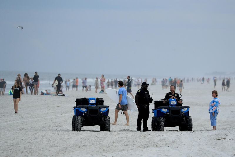 Police are seen speaking to people at the beach in Jacksonville Beach, Florida. Getty Images / AFP