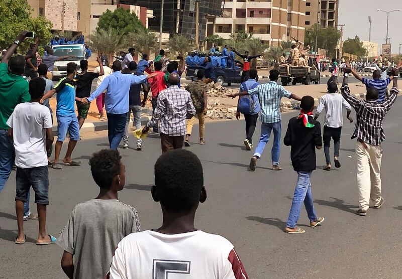 Sudanese protesters shout slogans as they block the road in front of riot police and an army convoy, during a demonstration against the military council, in Khartoum, Sudan, on Sunday, June 30, 2019. AP Photo