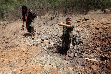 Members of the PKK inspect a crater reportedly caused by an air strikes by Turkish warplanes in 2015. Turkey continues to strike the region today. AFP