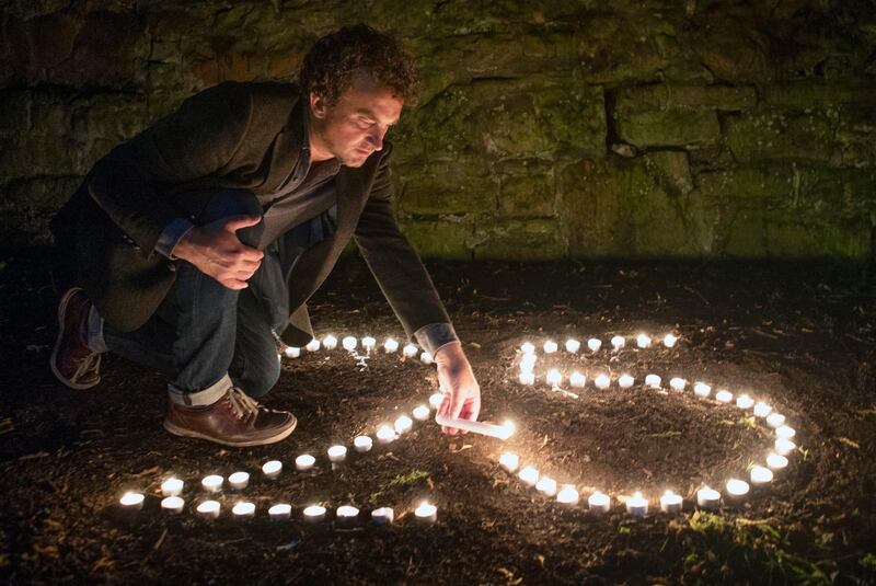 Bafta award-winning film director Samir Mehanovic, who came to the UK as an immigrant from the Bosnian war in 1995 and now lives in Scotland, lights candles to commemorate the 25th anniversary of the Srebrenica genocide, in Edinburgh, Scotland.  AP Photo