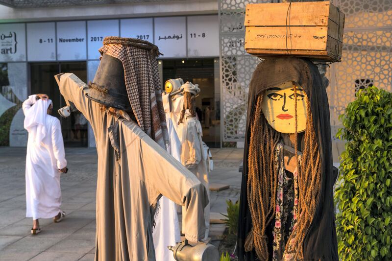 Abu Dhabi, United Arab Emirates, November 8, 2017:    A man walks past artist Abdullah Al-Saadi, Scarecrows, on the opening day of Abu Dhabi Art at Manarat Saadiyat on Saadiyat Island in Abu Dhabi on November 8, 2017. Christopher Pike / The National

Reporter: Melissa Gronlund
Section: Weekend