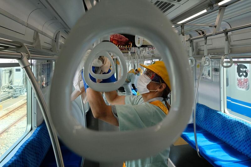 Workers of Seibu Railway Company disinfect a railcar to prevent the spread of the COVID-19 coronavirus at the company's Kotesashi railcar base in Tokorozawa, Saitama Prefecture.  AFP