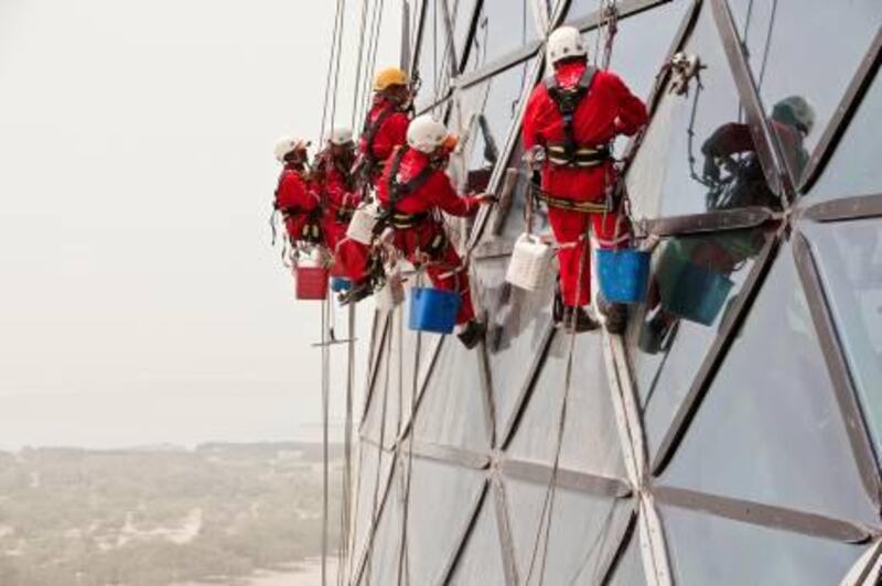 ABU DHABI, UNITED ARAB EMIRATES,  September 19, 2012. Rope Access cleaners from Grako clean the windows of the Capitol Gate tower adjacent to ADNEC in Abu Dhabi. (ANTONIE ROBERTSON / The National)