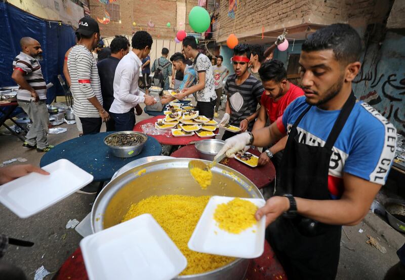 Residents of Ezbet Hamada in Cairo's Mataria district prepare for a mass iftar meal in Cairo, Egypt. Reuters