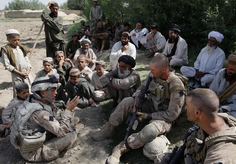 This July 2, 2009 photo shows Josh Habib, far left, an interpreter for the US Marines, speaking with Afghan villagers and two Marines in the Nawa district of Afghanistan's Helmand province. AP Photo