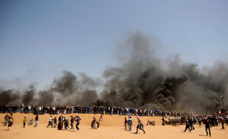 Palestinian protesters stand on sands hill. Adel Hana / AP Photo