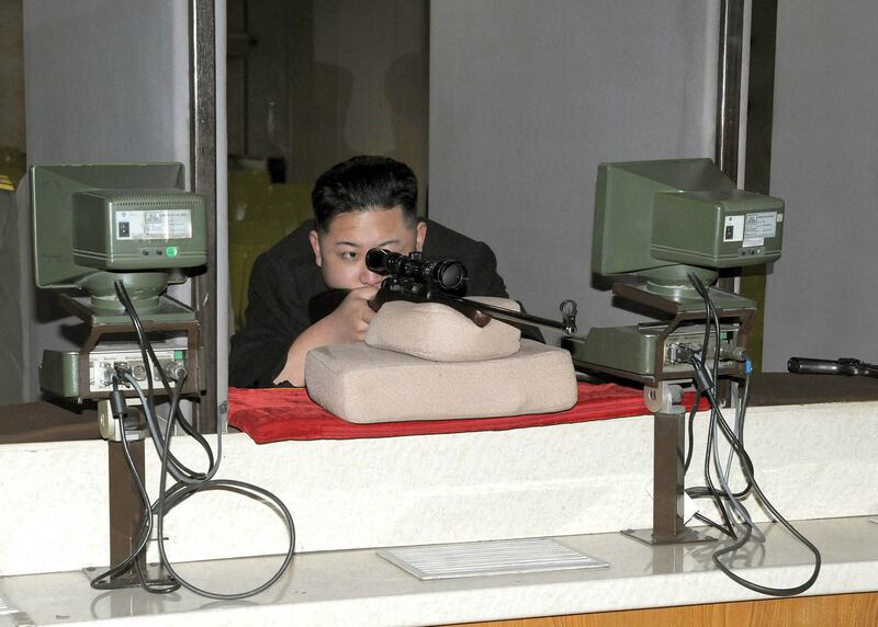 Kim Jong-un aims a gun on an inspection tour of the Sporting Bullet Factory in Pyongyang in February 2012. KCNA / AFP