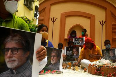 Fans of Bollywood actor Amitabh Bachchan hold posters of the actor while a Hindu priest (R) performs special rituals and prayers for the recovery of the actor as he tested positive for COVID-19, at a Hindu temple in Kolkata on July 12, 2020. Bollywood megastar Amitabh Bachchan, 77, tested positive for COVID-19 on July 11 and was admitted to hospital in Mumbai, with his actor son Abhishek -- who also announced he had the virus -- saying both cases were mild.


 / AFP / Dibyangshu SARKAR
