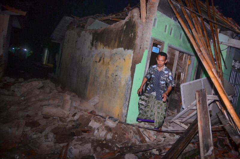 An Indonesian man walks out of a damaged house as he checks on his belongings after the 6.5 magnitude earthquake hit Tasikmalaya, West Java, Indonesia.  EPA / STR