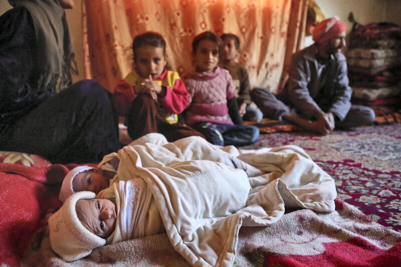 Umm Mohammed (L) sits with her two toddlers who suffer from malnutrition at their house in the town of Al-Nashabiyah in the besieged rebel-held Eastern Ghouta region outside Syria's capital Damascus on October 29, 2017.
The UN said last week that over 1,000 children in Eastern Ghouta were suffering from malnutrition, and medics in the region reported that at least two have died from malnutrition or its complications in October. / AFP PHOTO / Amer ALMOHIBANY