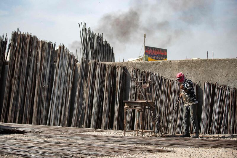 A man bends steel rods at a makeshift workshop in Raqqa.