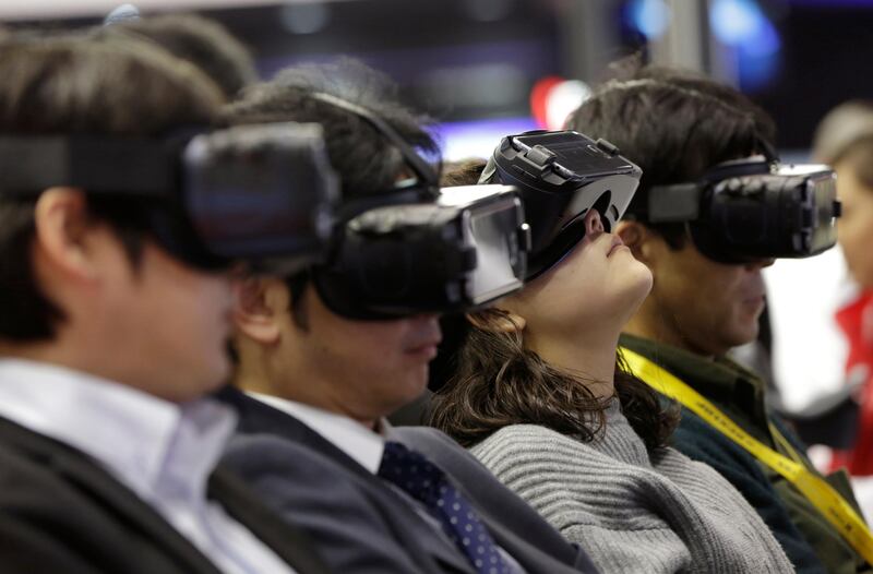 Guests try out a VR demonstration of a traffic situation at the Tokyo Motor Show.Eugene Hoshiko/AP