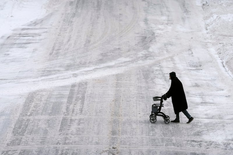 A pedestrian crosses an icy downtown street in Des Moines, Iowa. AP
