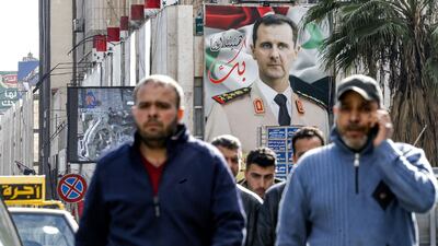 An image of President Bashar Al Assad looms over a street in Syrian capital Damascus. AFP