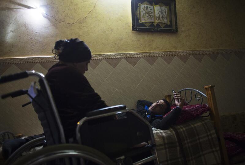 Wounded Palestinian woman  Asraah al-Namlah, and  her injured husband Wael in the evening as they listen to Arabic love songs in a room lit by safety lights during a power cut at their home in Rafa,Gaza January 20,2015. She lost both of her legs , and her son and husband each lost one leg  during last summer’s war between Israel and the Hamas-controlled Gaza Strip. The incident happened on one of the darkest days during the war that has been named ‘Black Friday’.Palestinians claim 130-150 were killed in the Rafa area of southern Gaza during a breakdown of a ceasefire agreement during a tunnel incident between Hamas and Israeli troops . 

The family was fleeing on foot trying to reach a safer area when an Israeli  rocket attack hit them .Her husband’s 11 -year old sister and his brother Yusef and his wife were killed in the attack.  Wael’s brother Yousef, a pharmacist , the only one working in the family and now all the family members are unemployed . Wael is hoping to find a way for his injured family to go to Germany for medical treatment . Heidi Levine for The National