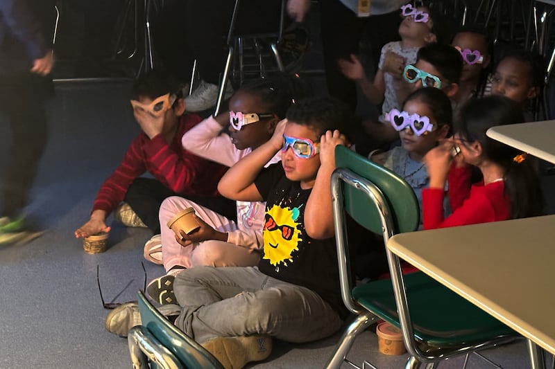 Pupils try out eclipse-viewing glasses at a school in Cleveland, Ohio. AP