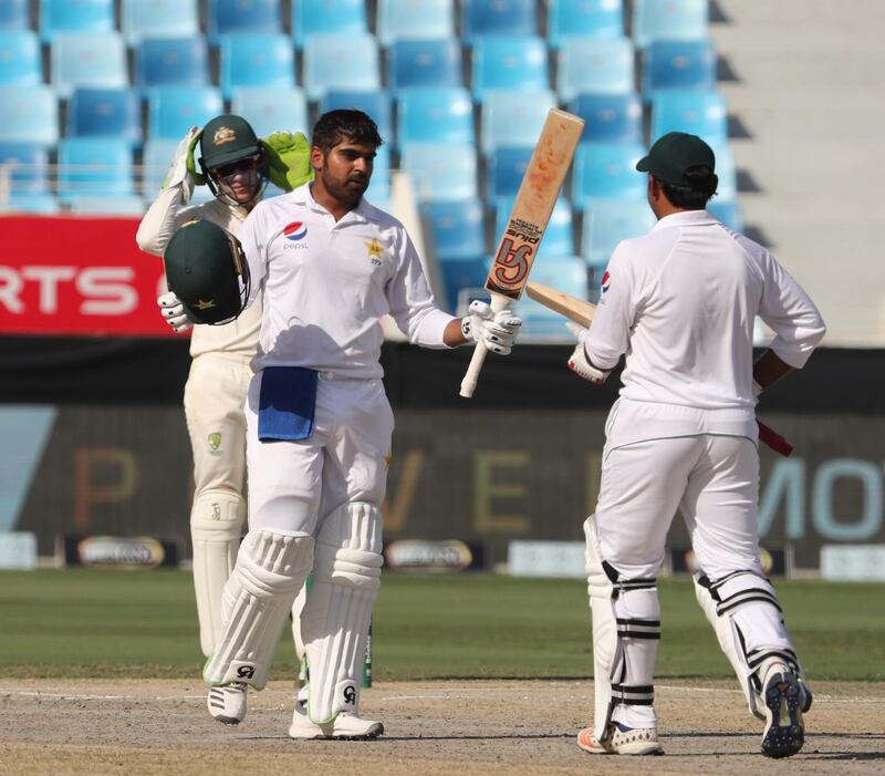 Pakistan cricketer Haris Sohall (L) gestures as he celebrates his century (100 runs) during day two of the first Test match in the series between Australia and Pakistan at Dubai International Stadium in Dubai on October 8, 2018. / AFP / KARIM SAHIB
