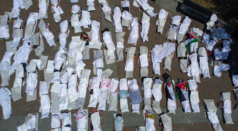 Artists lie in simulated body bags during a performance in support of the Palestinian people in Santiago, Chile. AP