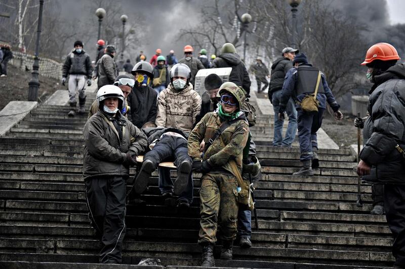 Protesters carry a wounded demonstrator. Hundreds of armed protesters charged police barricades. Protesters pushed the police back about 200 metres and were in control of most of the square they had occupied at the start of Ukraine’s three-month-old political crisis. Louisa Gouliamaki / AFP