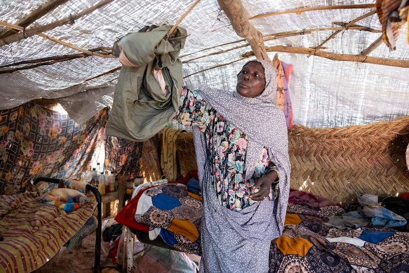 Sixty-five-year-old Sudanese refugee Fatima Kamoun Adam puts her shelter in order in the Adre refugee camp